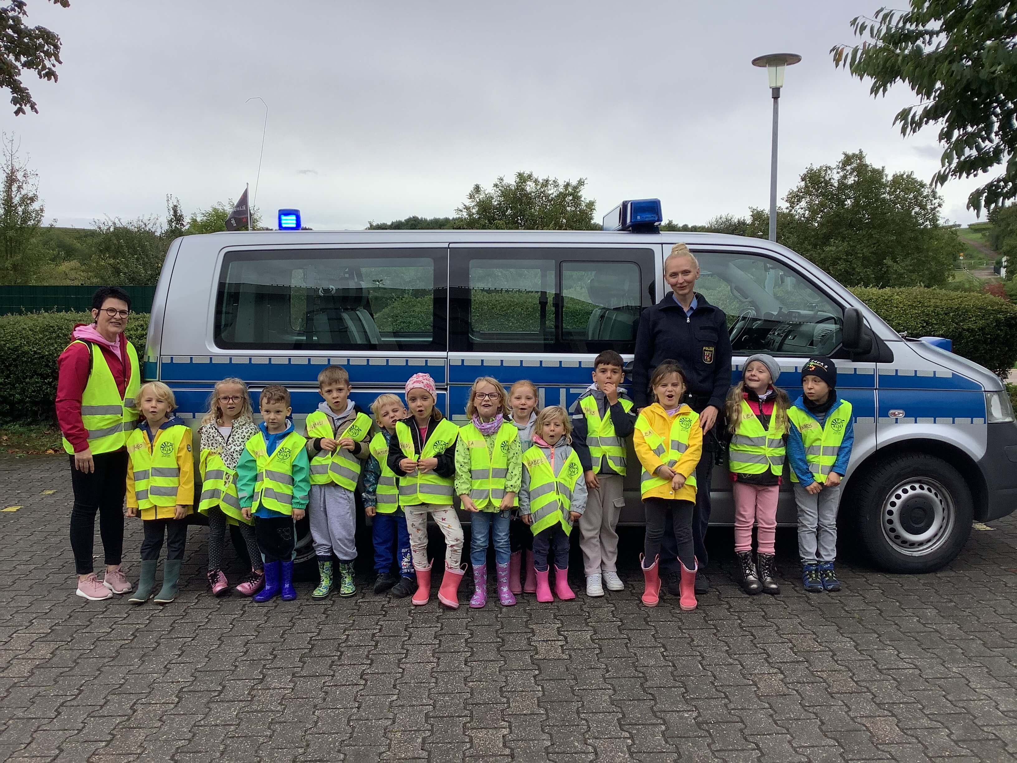 Gruppenfoto der Kinder vor einem Polizeiauto
